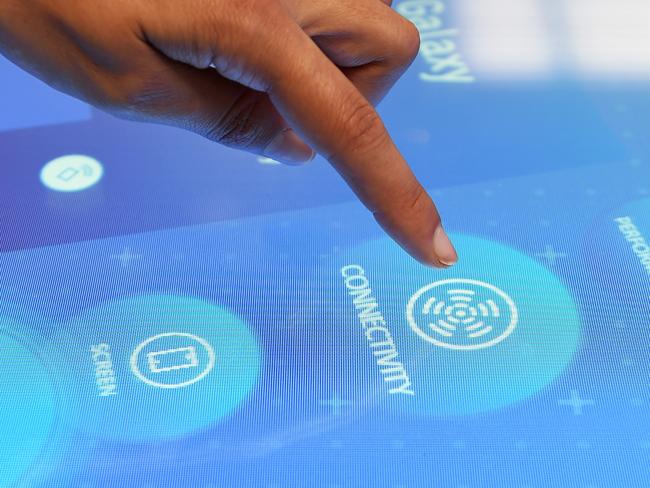 An employee demonstrates using an interactive product information table inside a Telstra Corp. Discovery store in Melbourne, Australia, on Tuesday, Feb. 9, 2016. Telstra, Australia's biggest phone company, is scheduled to report half-year results on Feb. 18. Photographer: Carla Gottgens/Bloomberg via Getty Images