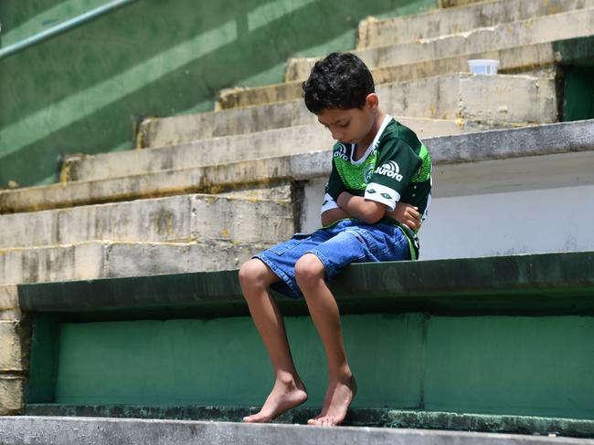 A boy sits alone on the stands during a tribute to the players of Brazilian team Chapecoense Real who were killed in a plane accident in the Colombian mountains, at the club's Arena Conda stadium in Chapeco, in the southern Brazilian state of Santa Catarina. Picture: AFP