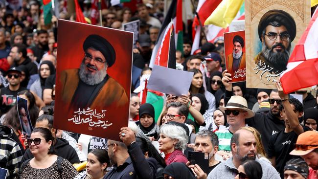 People hold up pictures of Hezbollah leader Hassan Nasrallah at a protest in Sydney in early October. Picture: Damian Shaw