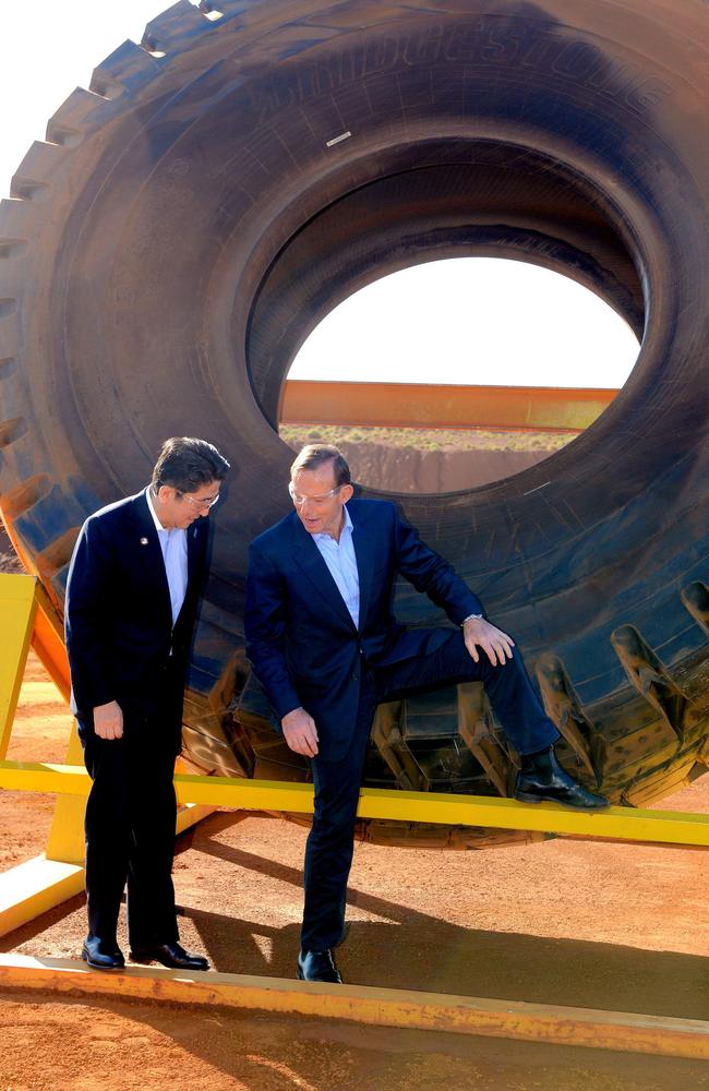 Abbott and Abe pose next to a haulage truck tyre during a tour of Rio Tinto's West Angelas iron ore mine in Pilbara, Western Australia. Picture: Alan Porritt.