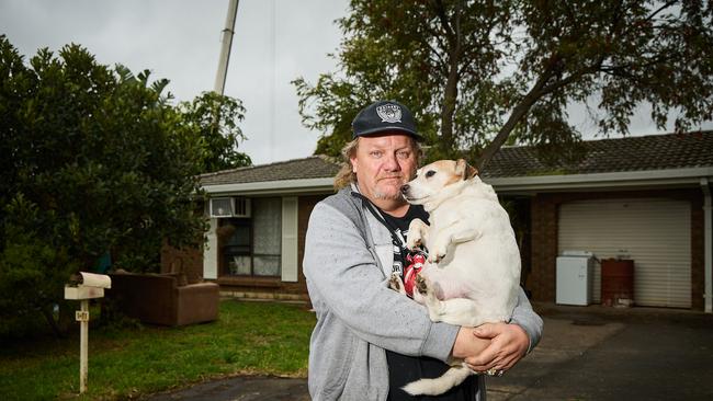 Andy Lambert with his dog, Jacko, outside his house that will soon be demolished to make room for construction along South Rd at Clovelly Park. Picture: Matt Loxton