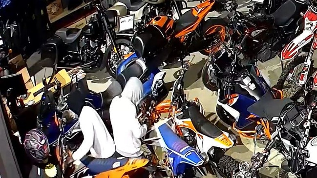 The pair were captured on CCTV allegedly taking their pick of which dirt bikes.