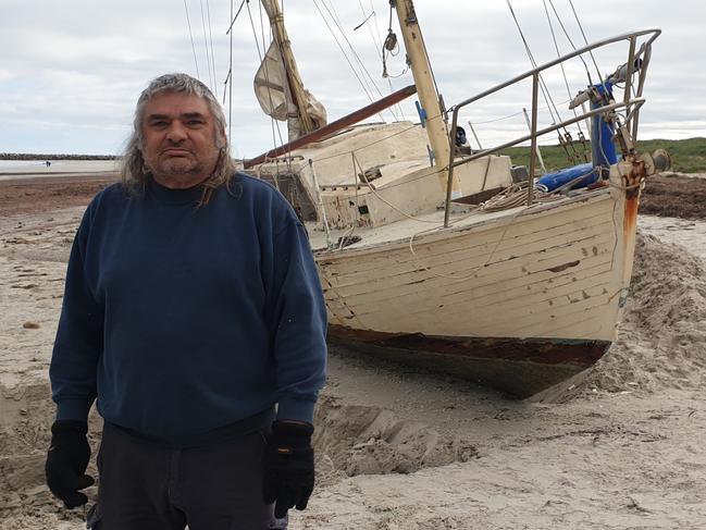 Novice sailor Claude Evans with his stranded yacht at North Haven. Picture:Colin James