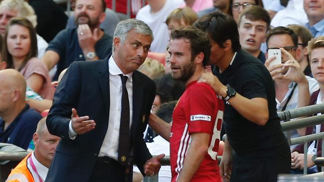 Manchester United's Jose Mourinho (L) talks with Juan Mata (R).