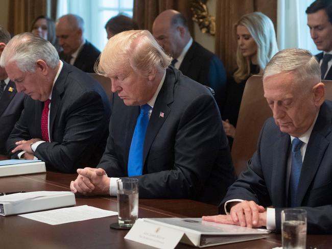 Donald Trump, Secretary of State Rex Tillerson and Secretary of Defense Jim Mattis prayed during a cabinet meeting overnight. Picture: AFP/Saul Loeb