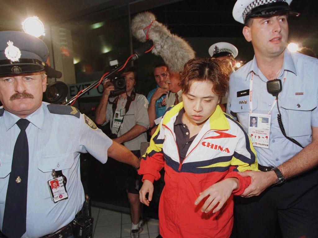 Chinese swimmer Yuan Yuan escorted by an Australian customs officer and a policeman after being caught smuggling illicit substances in 1998.