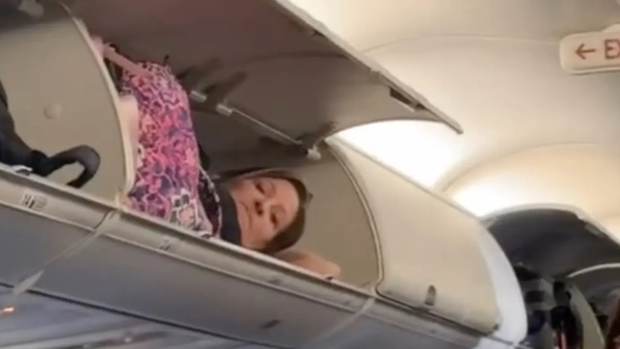 A woman can be seen laying in the overhead compartment of a Southwest Airlines flight. Picture: Storyful