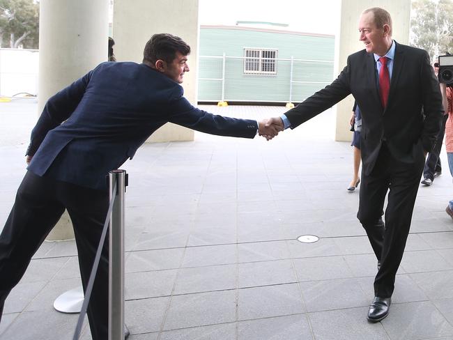 Labor Senator Sam Dastyari shakes hands with Fraser Anning as he arrives at Parliament House in Canberra today. Picture Kym Smith