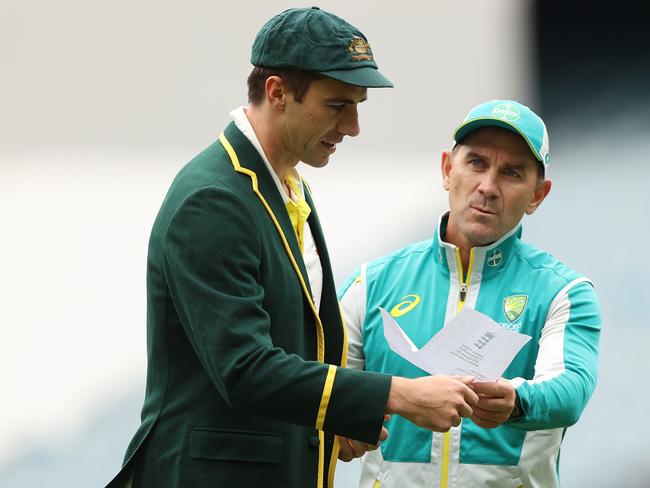 MELBOURNE, AUSTRALIA - DECEMBER 26: Pat Cummins of Australia and Australia head coach Justin Langer are seen with England's team list during day one of the Third Test match in the Ashes series between Australia and England at Melbourne Cricket Ground on December 26, 2021 in Melbourne, Australia. (Photo by Robert Cianflone/Getty Images)