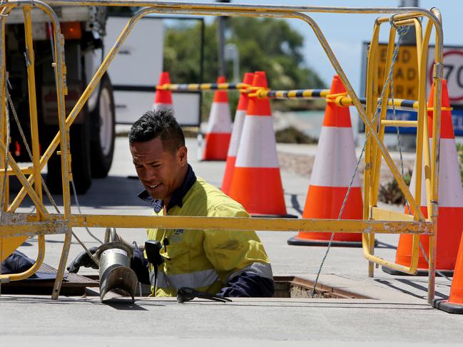 Workers laying/hauling fibre NBN cable along Dohle's Rocks Rd.  Levrone Lota checking the manhole where the cable is pulled  throughPicture : Chris Higgins