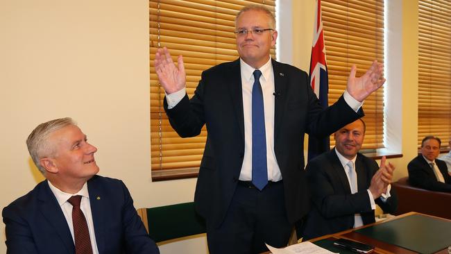 Prime Minister Scott Morrison (centre) takes centre stage at a joint party room meeting in Canberra as Deputy PM Michael McCormack (left) and Treasurer Josh Frydenberg look on. Picture: Kym Smith