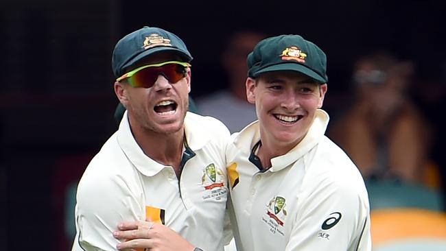 Australia's David Warner (L) celebrates with Matt Renshaw. AFP PHOTO / Saeed KHAN /