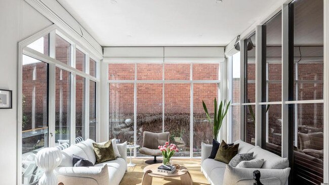 A sunny living and dining space is accompanied by a kitchen with Smeg appliances and granite benchtops.