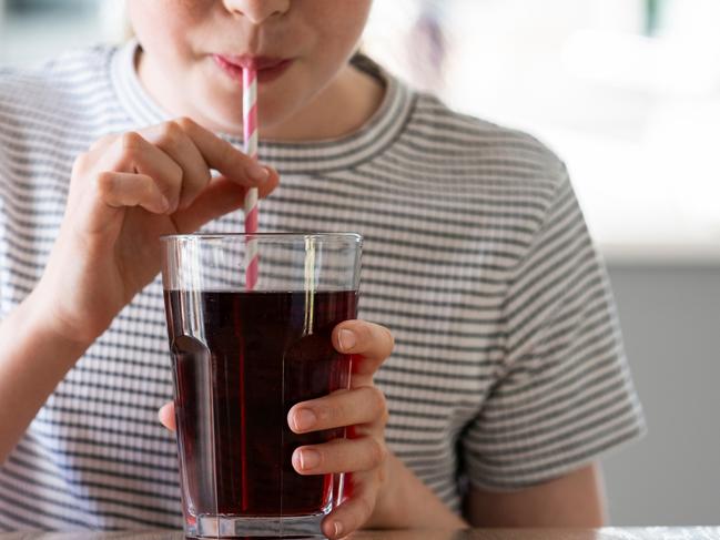 IStock generic of kids drinking -  Close Up Of Girl Drinking Sugary Fizzy Soda From Glass With Straw