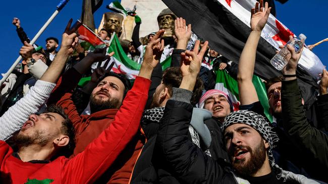 TOPSHOT - Syrian residents in Turkey wave Syrian opposition flags as they celebrate the fall of long-time ruler Bashar al-Assad after rebel fighters took control of the Syrian capital Damascus overnight, in Istanbul on December 8, 2024. Turkey's foreign minister said on December 8, 2024 the country wanted to help "guarantee security" in Syria after the fall of president Bashar al-Assad in the face of an offensive by Islamist-led rebels. (Photo by Yasin AKGUL / AFP)