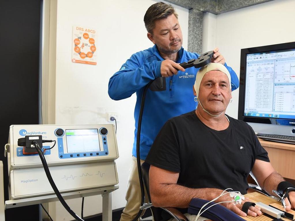 Professor Alan Pearce, one of Australia’s leading concussion researchers, using the TMS on former AFL player Rod Owen