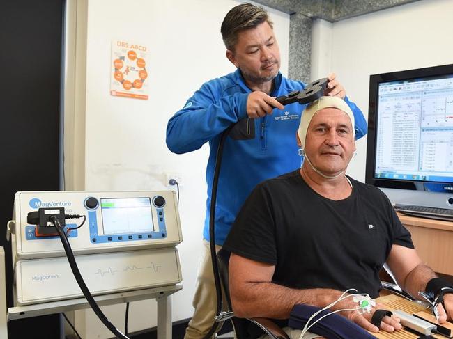 Professor Alan Pearce, one of Australia’s leading concussion researchers, using the TMS on former AFL player Rod Owen