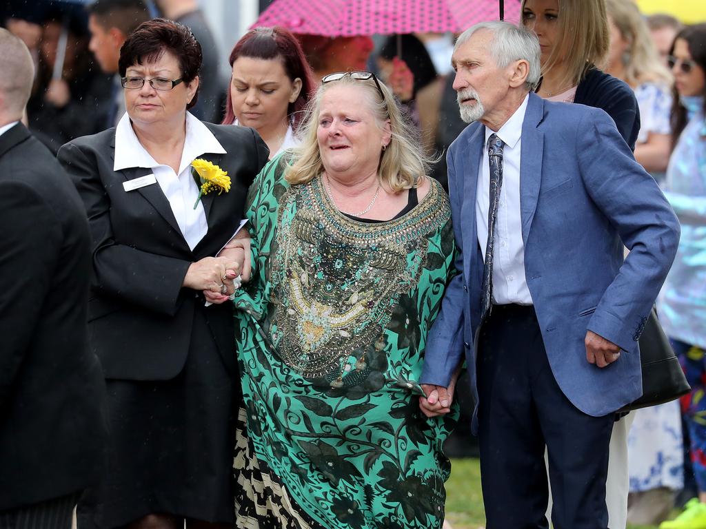 Michaela's mother Joanne Dunn (centre) and father Jim Dunn (right) is supported by funeral staff. Picture: Toby Zerna