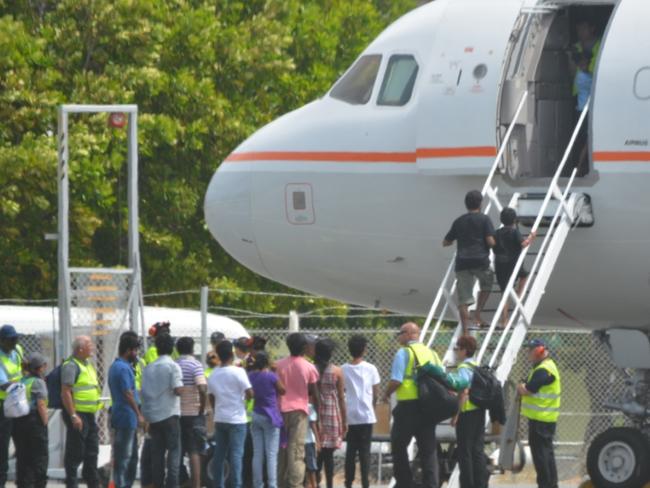 Asylum seekers prepare to board a plane at Cocos Island to fly to the Curtin Detention Centre in Western Australia.