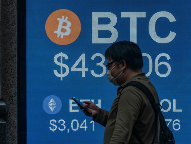 HONG KONG, CHINA - FEBRUARY 15: Pedestrians walk past a digital screen displaying the prices of cryptocurrencies Bitcoin on February 15, 2022 in Hong Kong, China. Cryptocurrencies are gaining popularity worldwide as investors seek to diversify into the new asset class despite wild swings in the valuations of assets like Bitcoin and Ethereum in the first weeks of the year. Buying and selling crypto is becoming common in many places, like Hong Kong, where regulators have so far avoided using a heavy hand to manage crypto platforms. (Photo by Anthony Kwan/Getty Images)