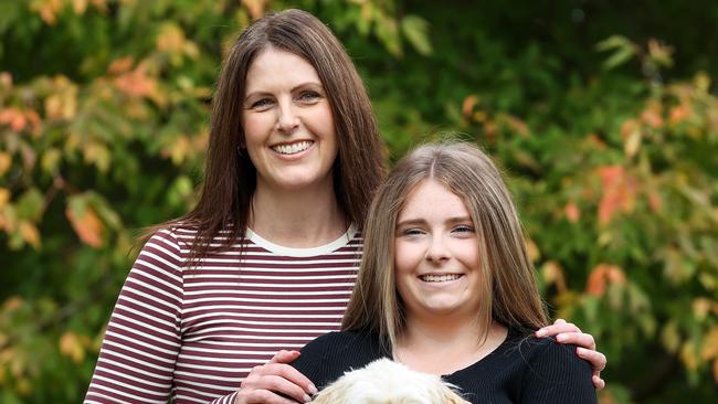 Taya, 16, was finally diagnosed with endometriosis after numerous trips to hospital. Taya is pictured with her mother Nicole and their pet dog Marley. Picture: Ian Currie