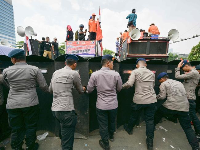 Policemen form a barricade with their shields as parliament members attempt to meet with people who gathered near the Parliament building in Jakarta on August 22, 2024 to protest a move to reverse the Constitutional Court's decision altering eligibility rules for candidates in a key election later this year. (Photo by BAY ISMOYO / AFP)