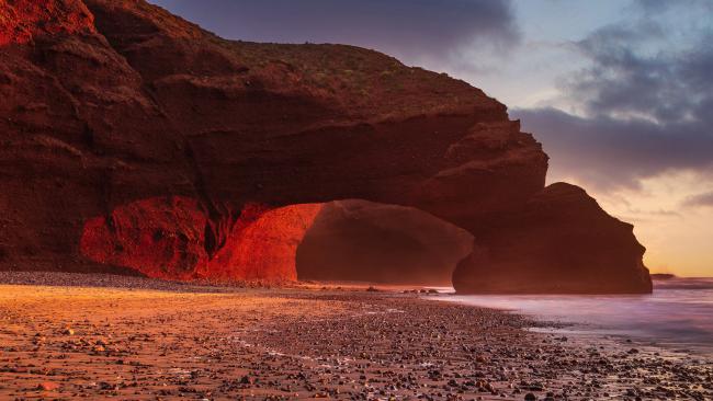 Best beach in Morocco? Legzira Beach
Head to the remote Legzira Beach for an epic beach experience. While its famous glowing red sandstone arch collapsed in 2016, there is still one left to see at low tide.