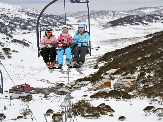 Skiers on chair lift at Charlotte Pass Ski Resort in Snowy Mountains, NSW. 