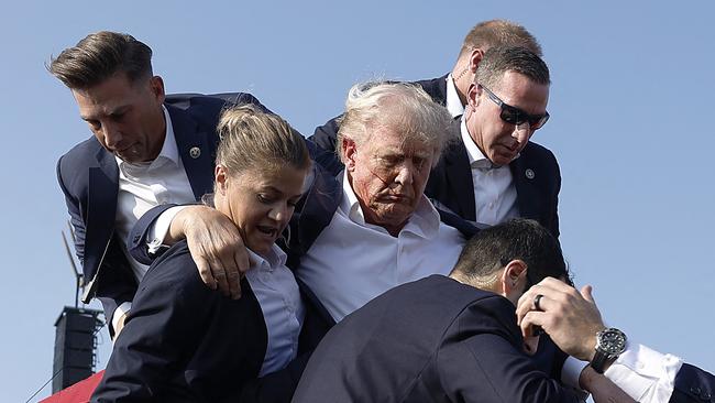 TOPSHOT - BUTLER, PENNSYLVANIA - JULY 13: Republican presidential candidate former President Donald Trump pumps his fist as he is rushed offstage during a rally on July 13, 2024 in Butler, Pennsylvania. Butler County district attorney Richard Goldinger said the shooter is dead after injuring former U.S. President Donald Trump, killing one audience member and injuring another in the shooting.   Anna Moneymaker/Getty Images/AFP (Photo by Anna Moneymaker / GETTY IMAGES NORTH AMERICA / Getty Images via AFP)