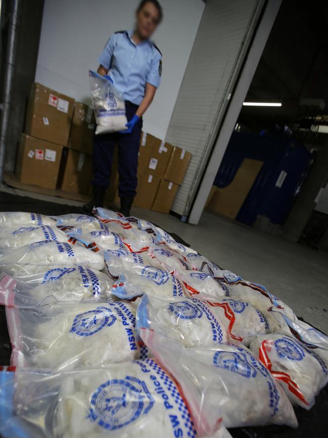 A police officer with some of the bags of ice allegedly shipped from Central America. Picture: NSW Police