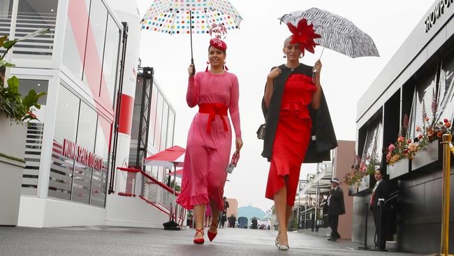 Racegoers shelter from the rain. Picture: AAP Image/Dave Crosling