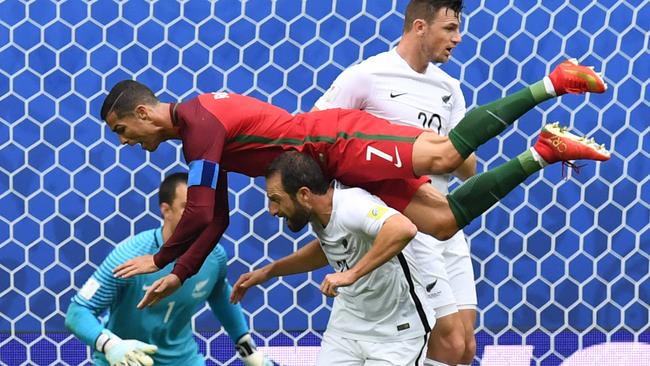 Portugal's forward Cristiano Ronaldo (L) falls over New Zealand's defender Andrew Durante.