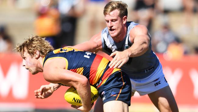 Rory Sloane of the Crows gets caught by Tom Jonas of Power.