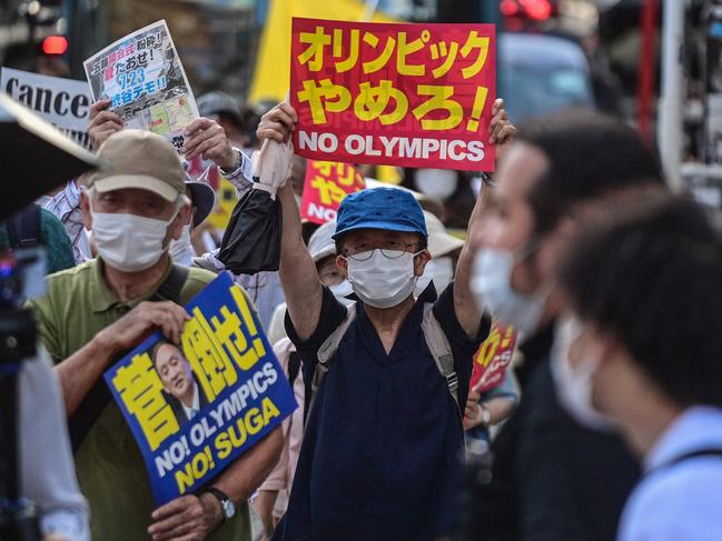 TOPSHOT - A man holds a placard during a protest against the hosting of the Tokyo 2020 Olympic Games in Tokyo on July 23, 2021. (Photo by Philip FONG / AFP)