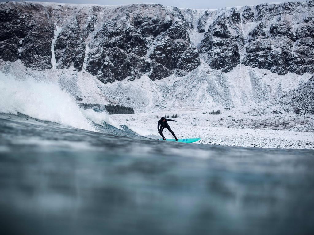 A surfer rides a wave on March 10, 2018 in Unstad, northern Norway, Lofoten islands, within the Arctic Circle as air temperature drops minus 13°C and water temperature above 4°C. Picture: AFP