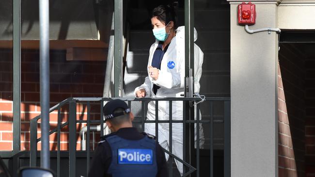 A forensic officer searches the Bedford St apartment block. Picture: Lawrence Pinder