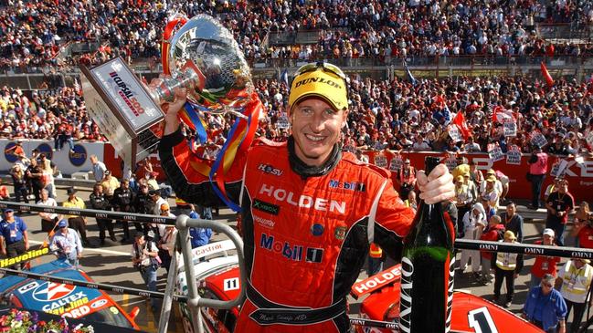 Supercars superstar Mark Skaife holds up his trophy after an iconic win in Adelaide.