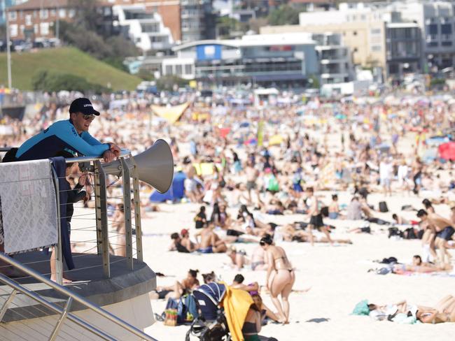 SYDNEY, AUSTRALIA - NewsWire Photos OCTOBER 05, 2020 - A lifeguard pictured watching the crowd at Bondi Beach on Monday October 05, 2020 as temperatures reached 30 degrees. Picture: NCA NewsWire / Christian Gilles