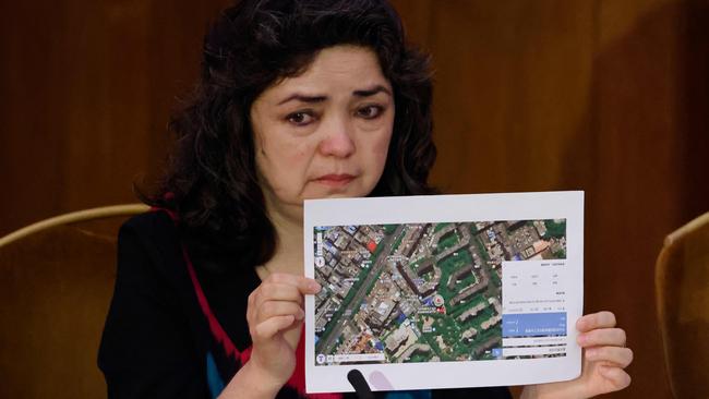 Witness Uyghur teacher Qelbinur Sidik holds up a photograph of the hospital where she says she underwent a forced sterilisation procedure on the first day of hearings at the "Uyghur Tribunal" on June 4, 2021. Picture: Tolga Akmen / AFP.