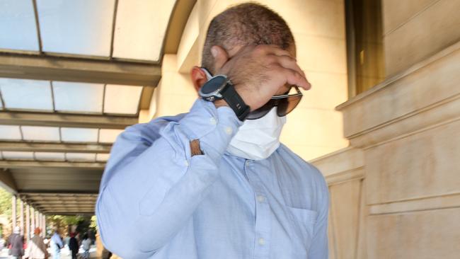 Moujtaba Joubouri hides his face as he leaves court on Tuesday. Picture: Brett Hartwig