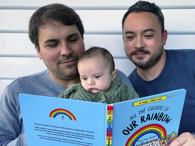 Dads Daniel Barnett and Daniel Gray-Barnett reading to son Till Barnett. The new book, All the Colours of Our Rainbow, has been written and illustrated by Daniel Gray-Barnett. Picture: Supplied.