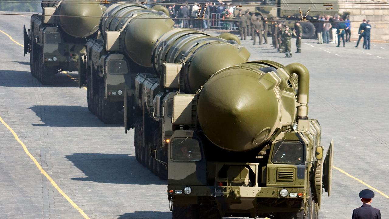 A Russian policeman stands in front of convoy of nuclear missiles in a military parade rehearsal in Moscow.