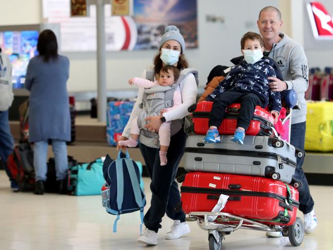 Barry Smith meets his wife Sarah and children Henry, 5, and Sienna, nine months, at Adelaide Airport ahead of the new restrictions with Victoria coming into force on Tuesday night at midnight. Picture: NCA NewsWire / Kelly Barnes