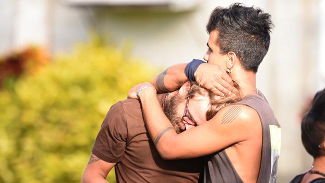 Backpackers comfort each other outside the Home Hill Backpackers after three people were stabbed. Picture: Zak Simmonds