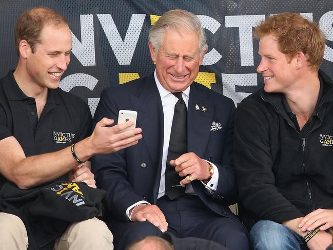 FILE PICS -  LONDON, ENGLAND - SEPTEMBER 11:  Prince William, Duke of Cambridge, Prince Harry and Prince Charles, Prince of Wales look at a mobile phone as they watch the athletics at Lee Valley Track during the Invictus Games on September 11, 2014 in London, England. The International sports event for 'wounded warriors', presented by Jaguar Land Rover, is just days away with limited last-minute tickets available at www.invictusgames.org  (Photo by Chris Jackson/Getty Images)