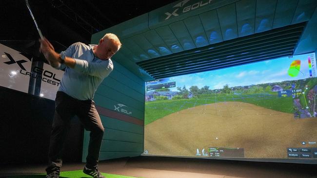 Premier Jeremy Rockliff having a swing on the X-Golf Launceston simulator after announcing a new small business start-up permit. Picture: Supplied