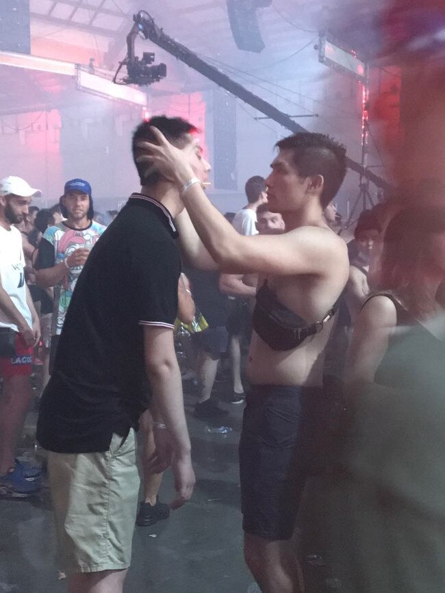 A man massages his friend at the Hardcore festival.