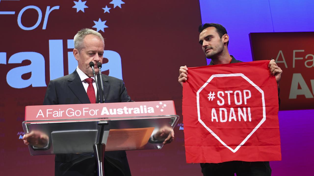 An anti-Adani protester gets on stage with Bill Shorten speaks at the Labor Party National Conference in Adelaide in December 16. Picture: Lukas Coch/AAP