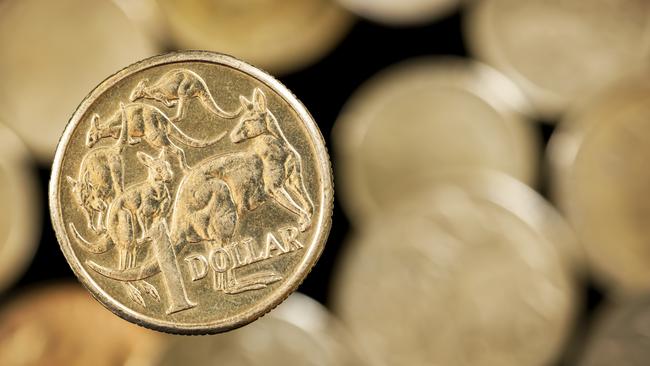 Australian one dollar coin over blurred golden background.