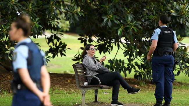 NSW Police officers ask a woman to move on while on patrol at Rushcutters Bay park. Picture: AAP